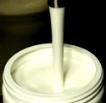 Luscious Cream Streaming Into a Jar From a Filling Machine